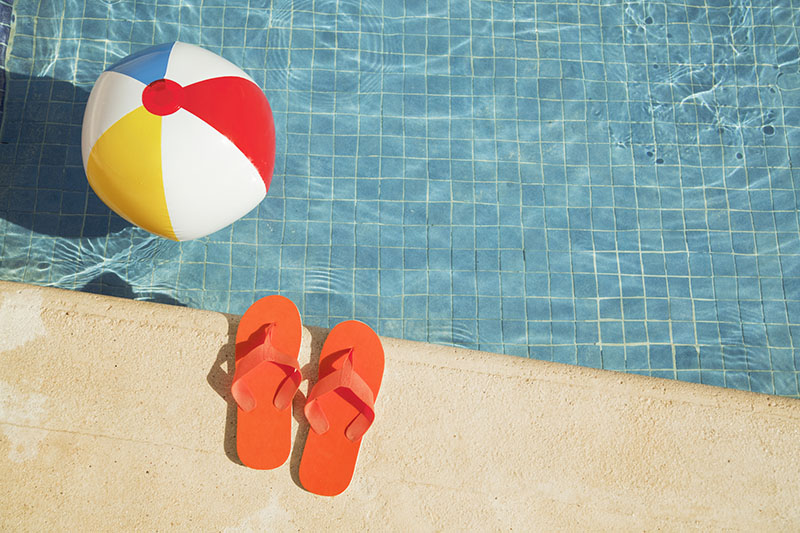 Flipflops and a beach ball at the pool